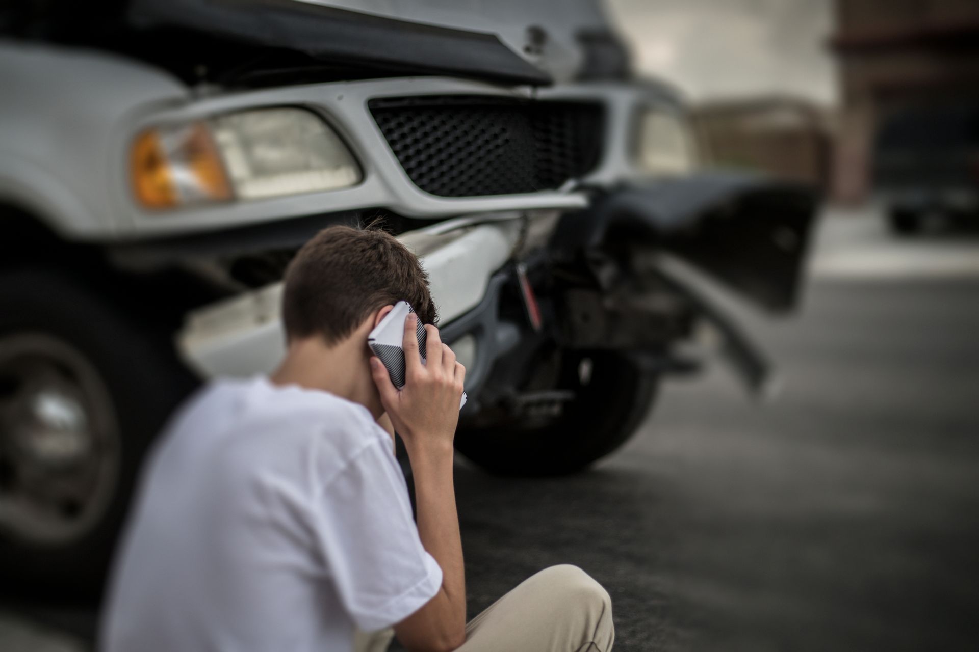 A person is holding a tire in front of a stack of tires.