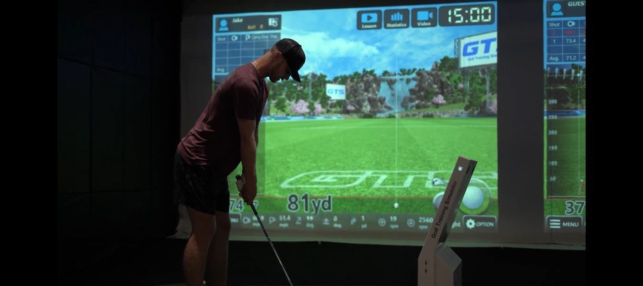 a man is playing golf in front of a screen