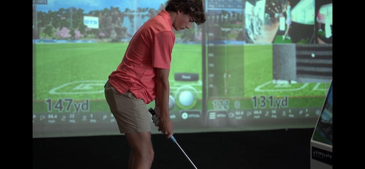 a man is swinging a golf club in front of a screen