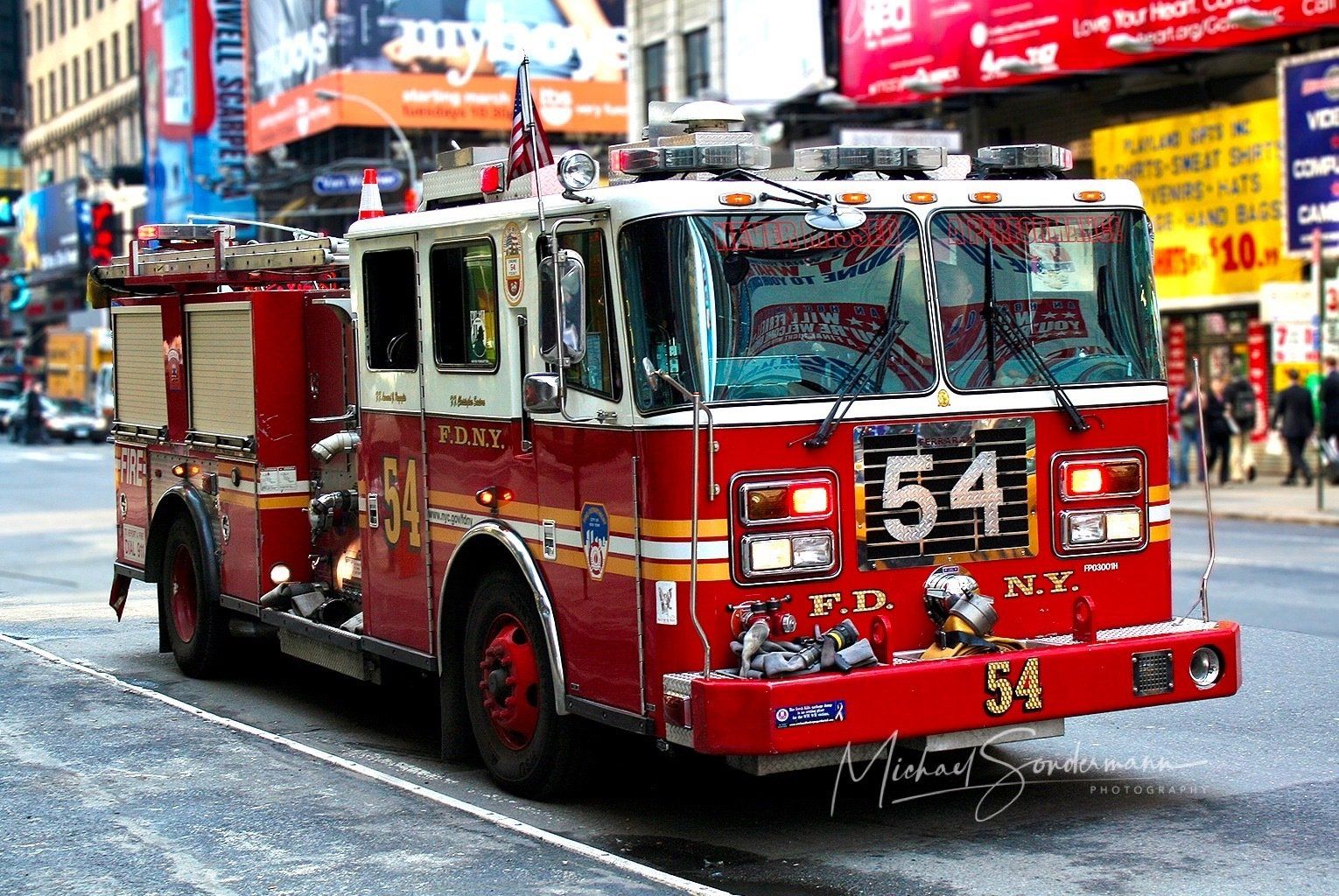 Ein roter Feuerwehrtruck der New Yorker Feuerwehr steht gerade mit Blaulicht bei einen Einsatz in China Town.