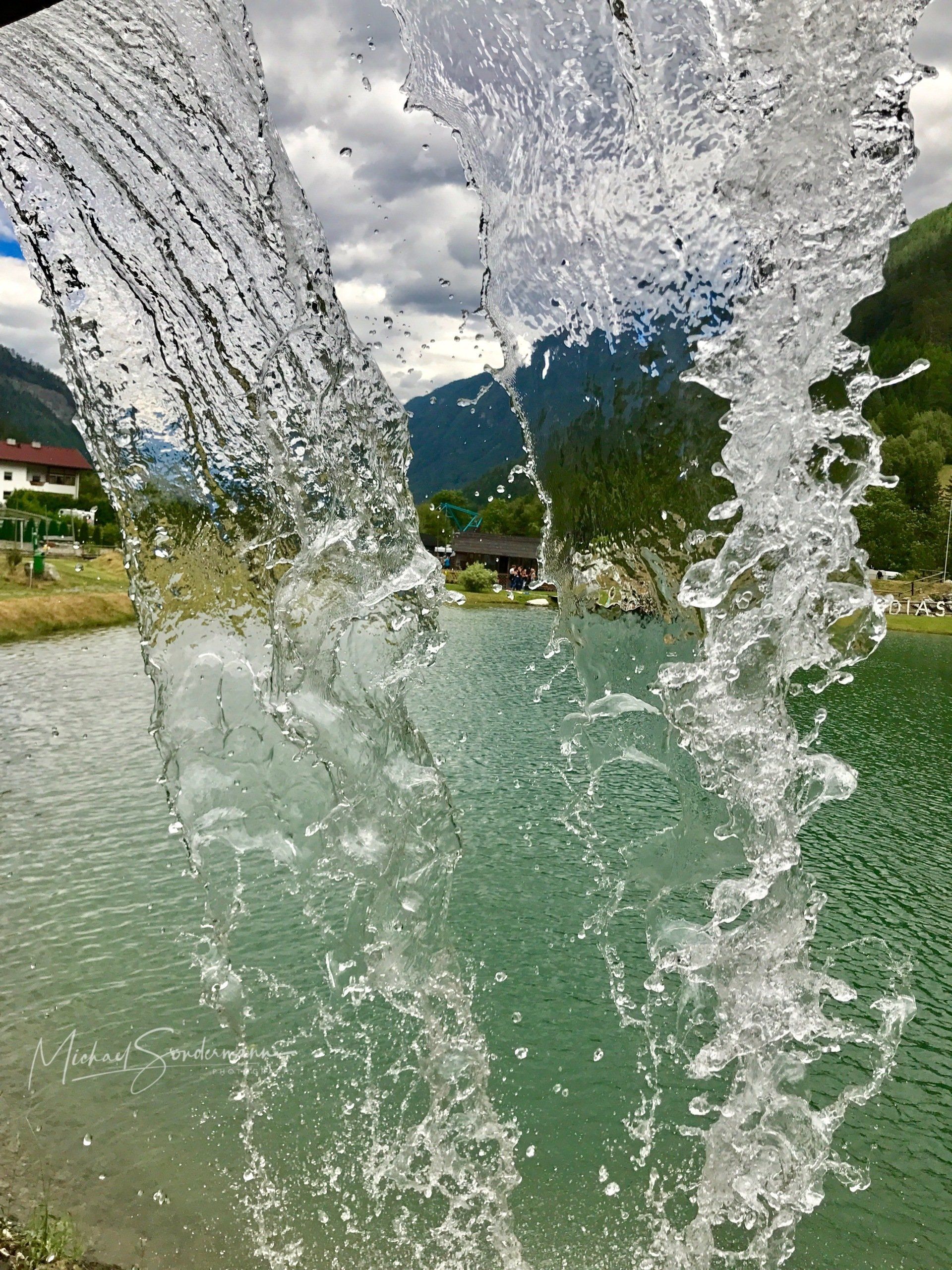 Ein schöner Blick unter einem Wasserfall vor einem Badesee