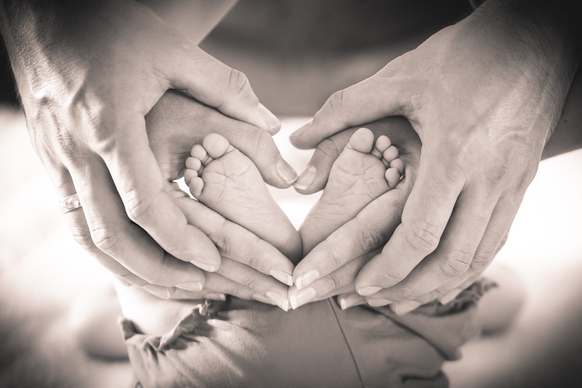 Eine Familie formt mit ihren Füßen ein Herz.