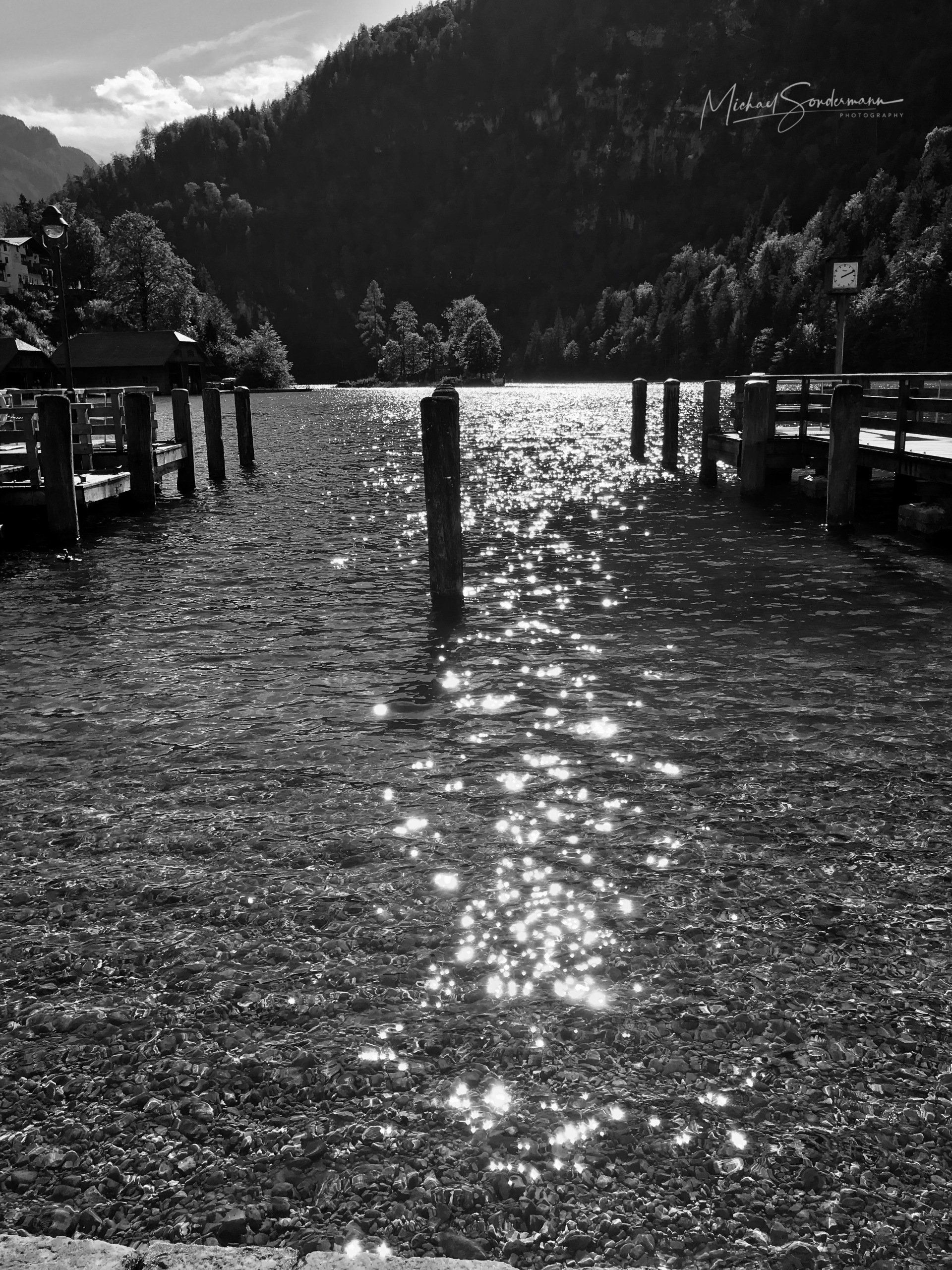 Ein Blick auf den Anlegesteg am Königssee in Bayern in schwarz weiss Optik.