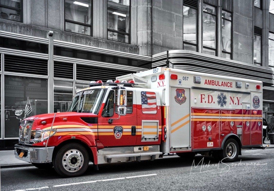 Ein weiss roter Rettungswagen der New Yorker Feuerwehr fährt gerade vzu einen Einsatz in New York.