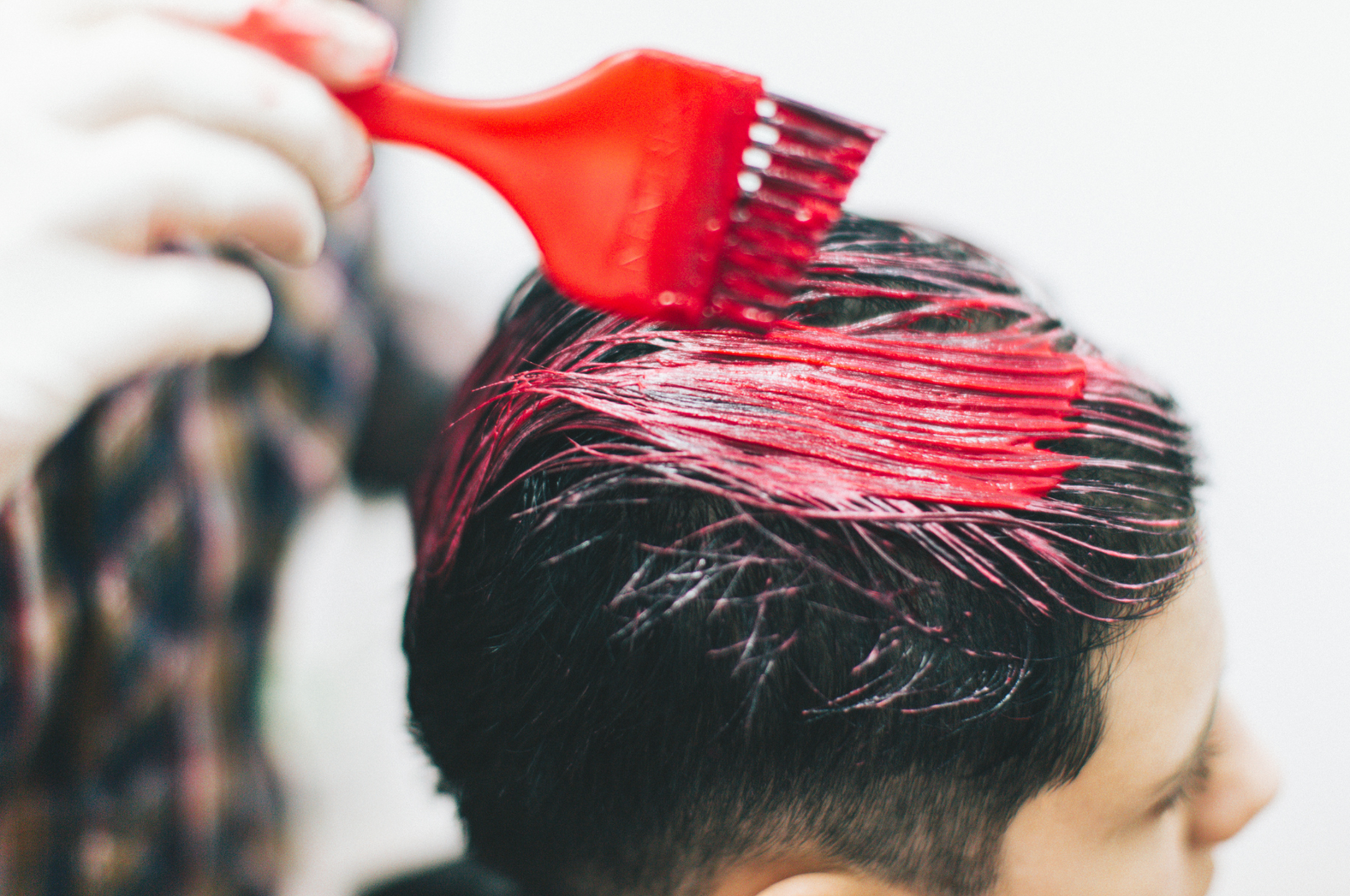 A woman is getting her hair dyed in a salon.