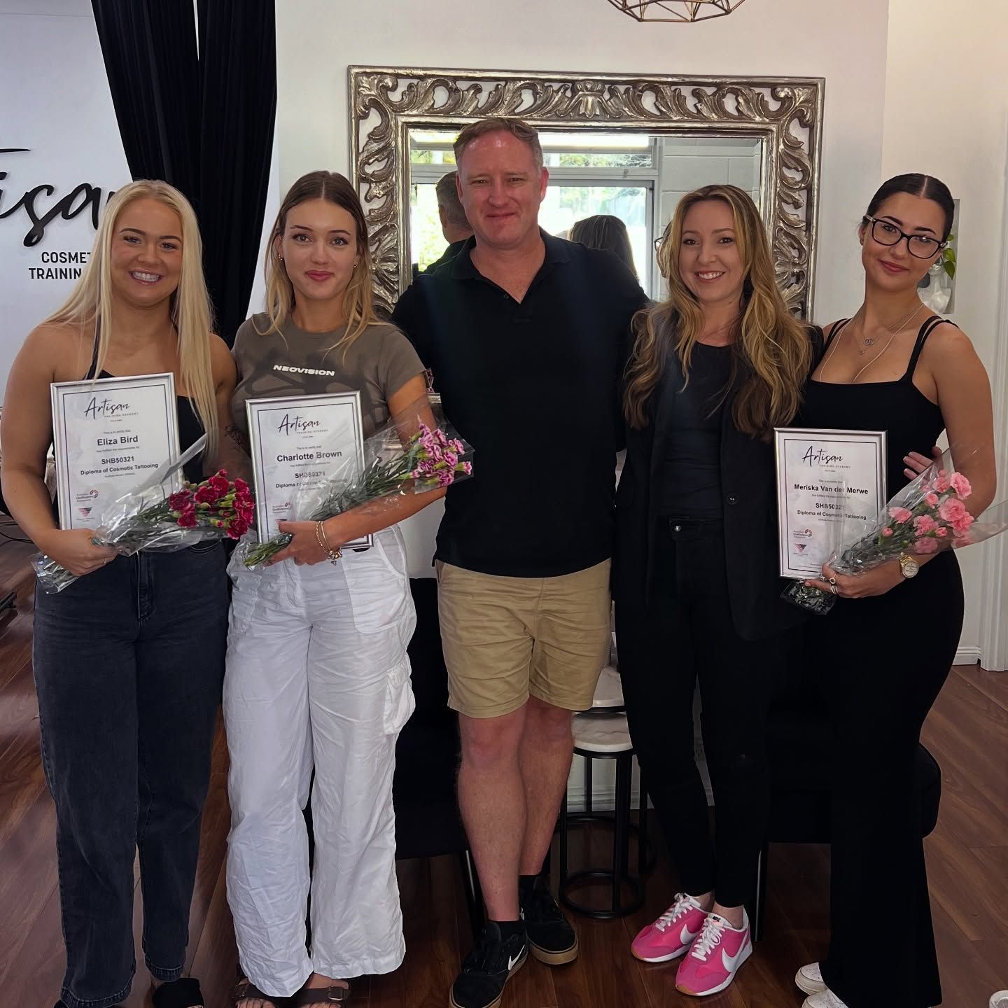 Five People Holding Certificates and Flowers Pose in a Salon — Artisan Cosmetic Tattoo & Beauty in Worongary, QLD