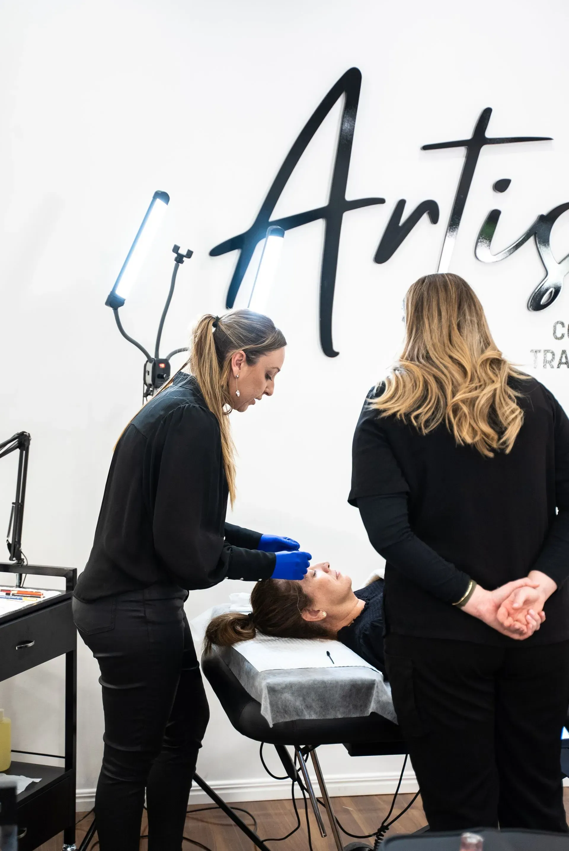 Two Women in Black Perform Eyebrow Microblading — Artisan Cosmetic Tattoo & Beauty in Worongary, QLD