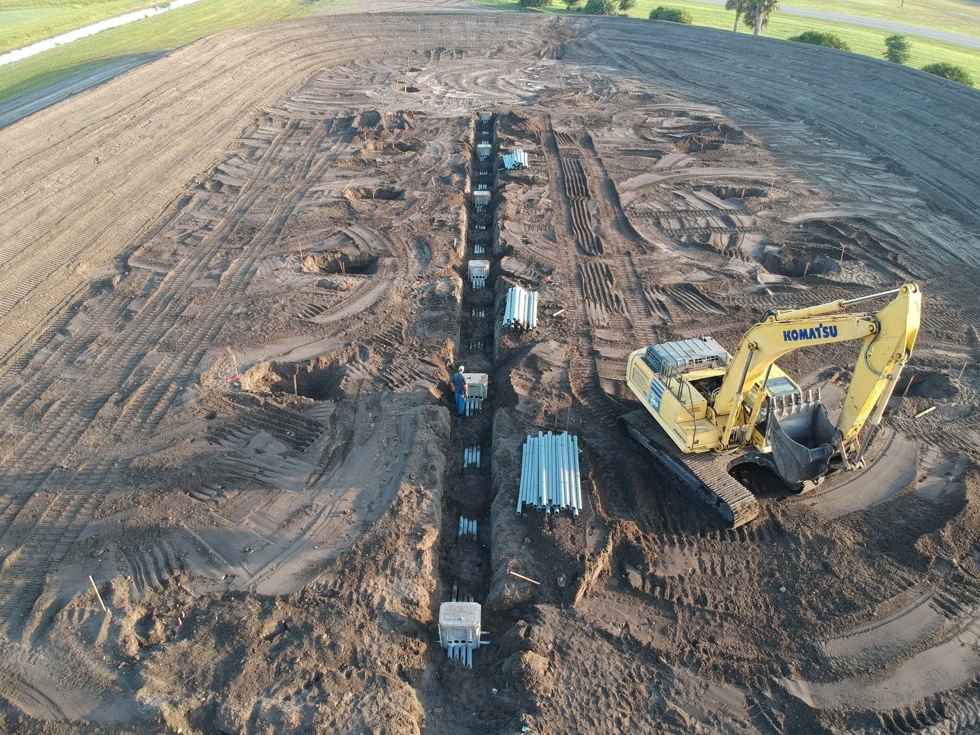 Workers Installing Thin Long Pipes Underground — Clewiston, FL — Ridgdill & Son