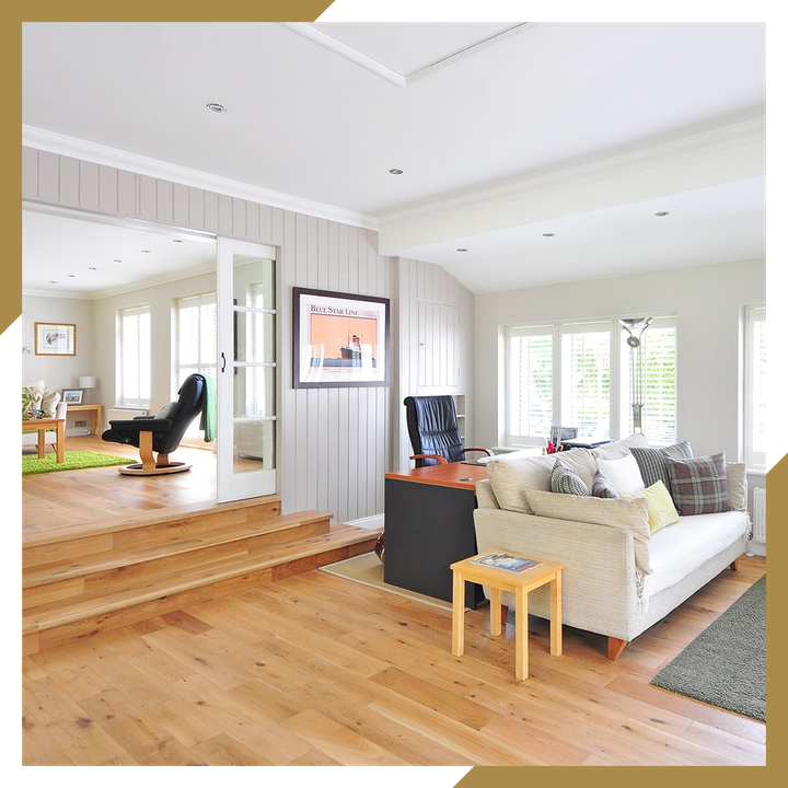 A living room with hardwood floors , a couch and a chair.