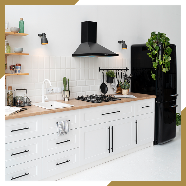 A kitchen with white cabinets and a black refrigerator.