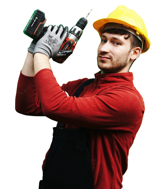 A man wearing a hard hat and overalls is holding a trowel