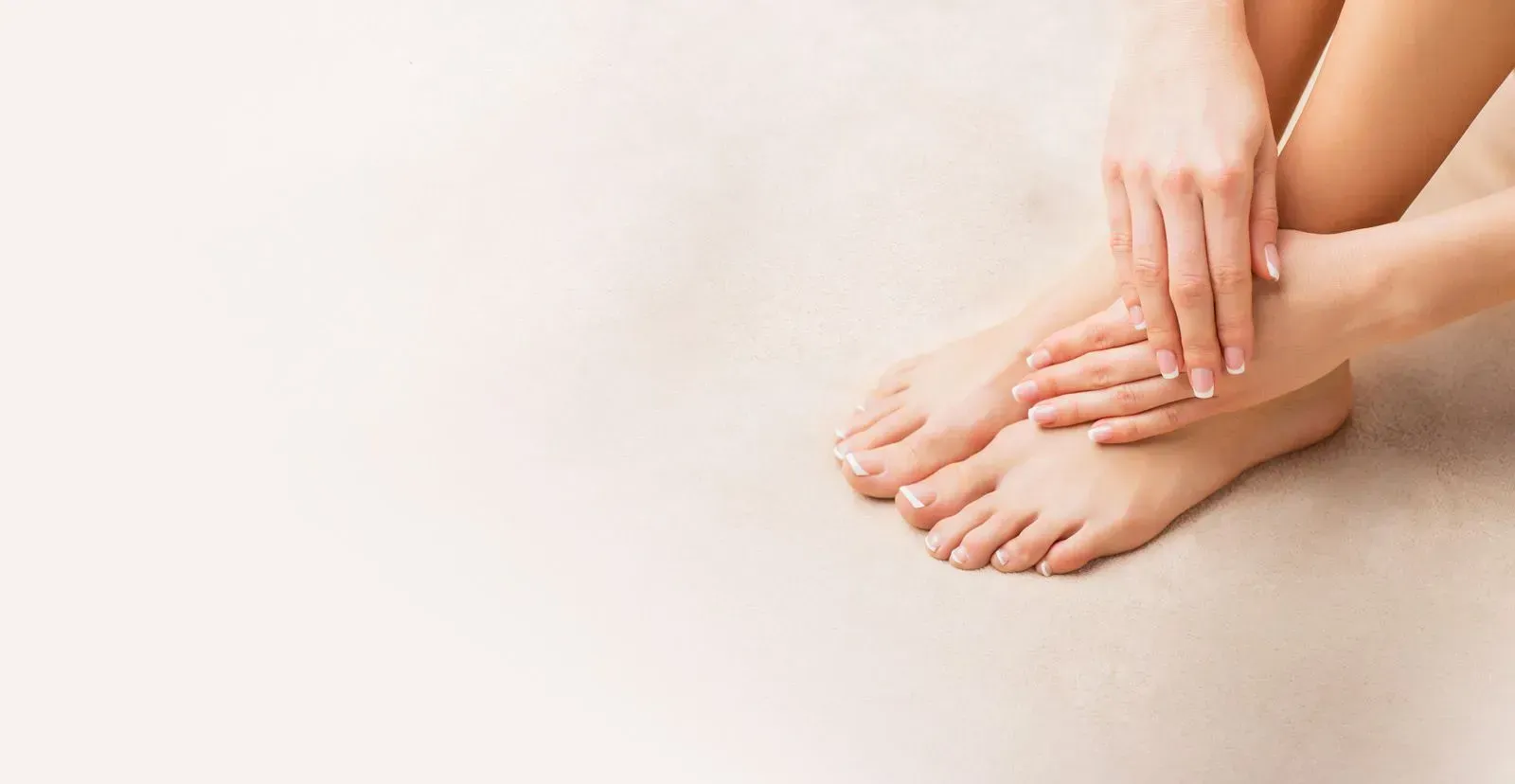 Eine Frau sitzt auf dem Boden und berührt ihre Füße.