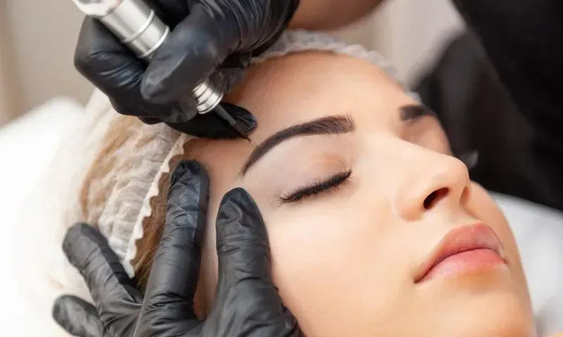 Eine Frau lässt sich Permanent Make-up auf die Augenbrauen machen.