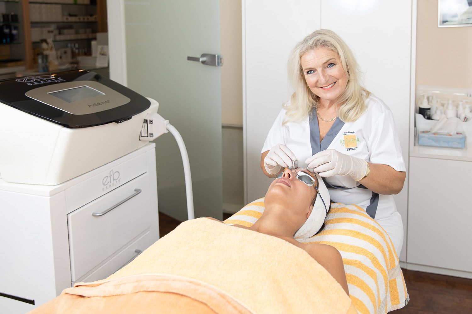 Eine Frau gibt einer anderen Frau in einem Spa eine Gesichtsbehandlung.