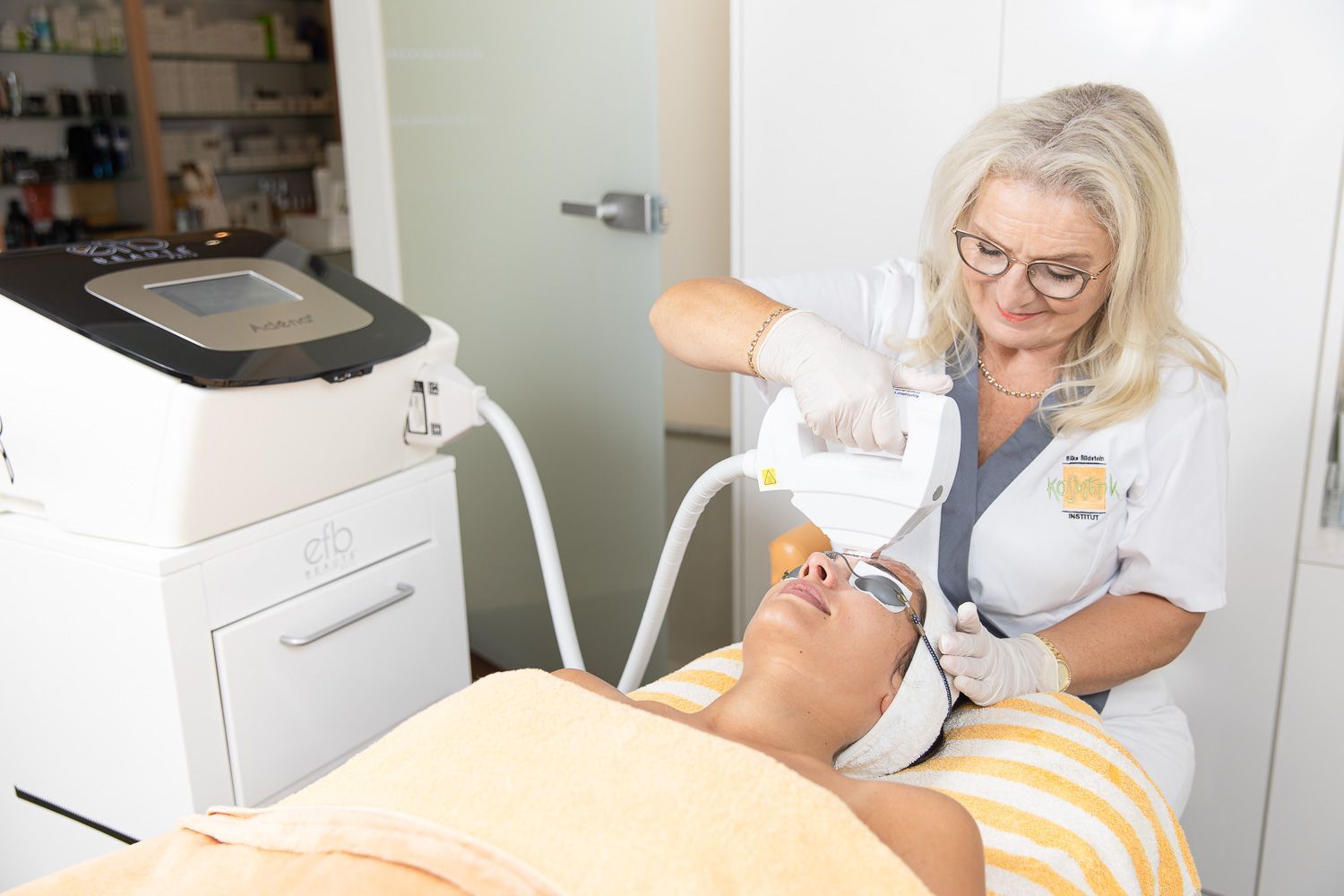 Eine Frau bekommt in einem Schönheitssalon eine Laserbehandlung im Gesicht.