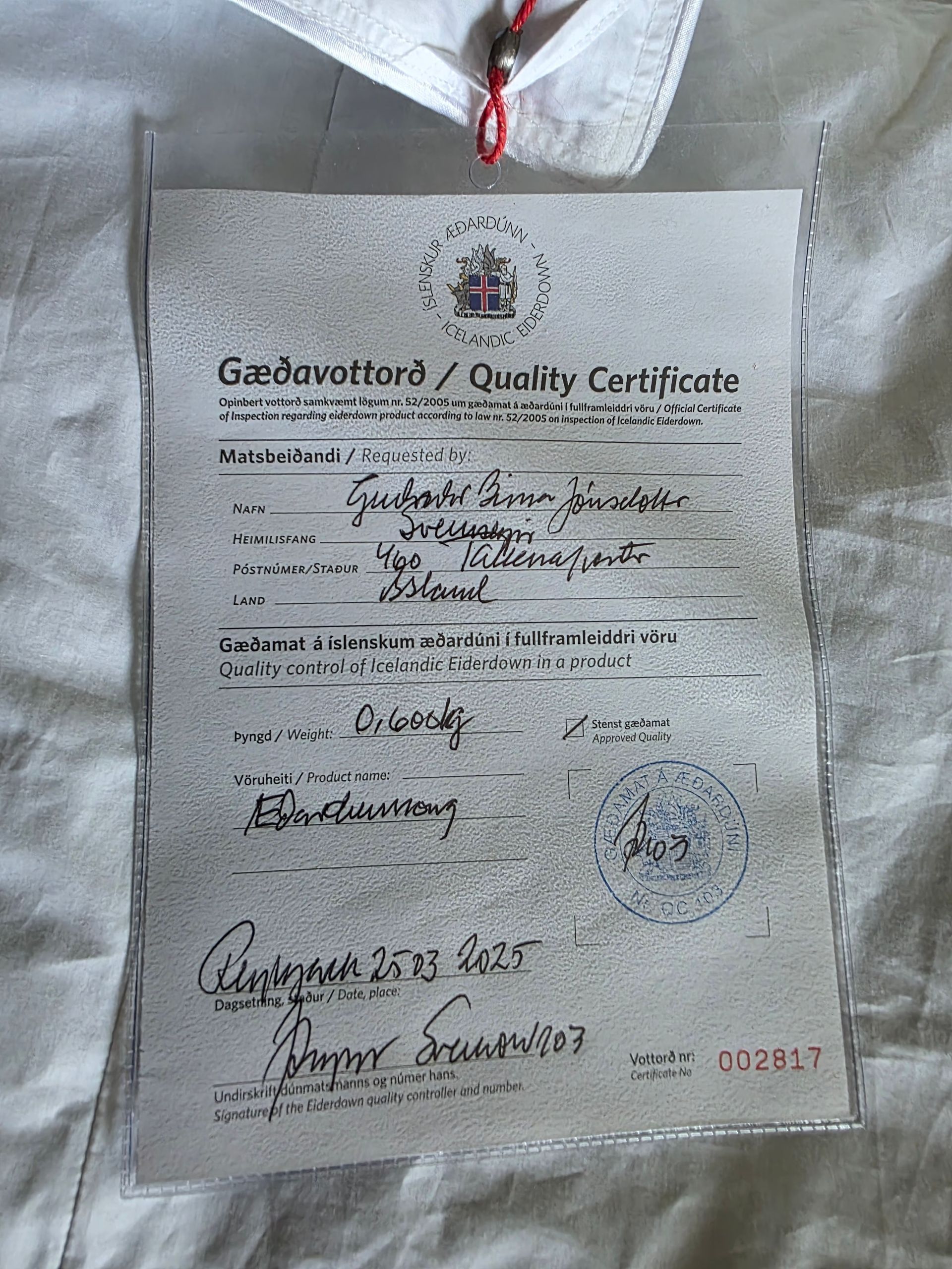 Quality certificate in a plastic sleeve, with handwritten details and a seal.