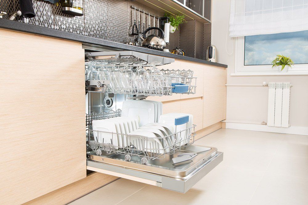 A Kitchen Dishwasher Open and Filled With Dishes and Glasses — Tony Brown Plumbing & Gas Services in South Grafton, NSW