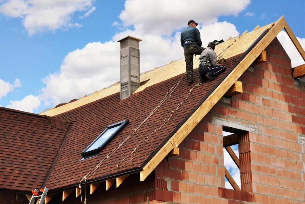 Two Men Are Working on the Roof of a House — Tony Brown Plumbing & Gas Services in South Grafton, NSW