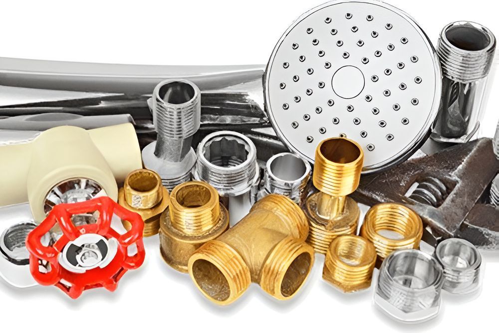 A Bunch of Plumbing Parts and Tools on a White Background — Tony Brown Plumbing & Gas Services in South Grafton, NSW