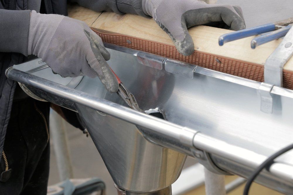 A Person is Cutting a Piece of Metal With a Pair of Scissors — Tony Brown Plumbing & Gas Services in Maclean, NSW