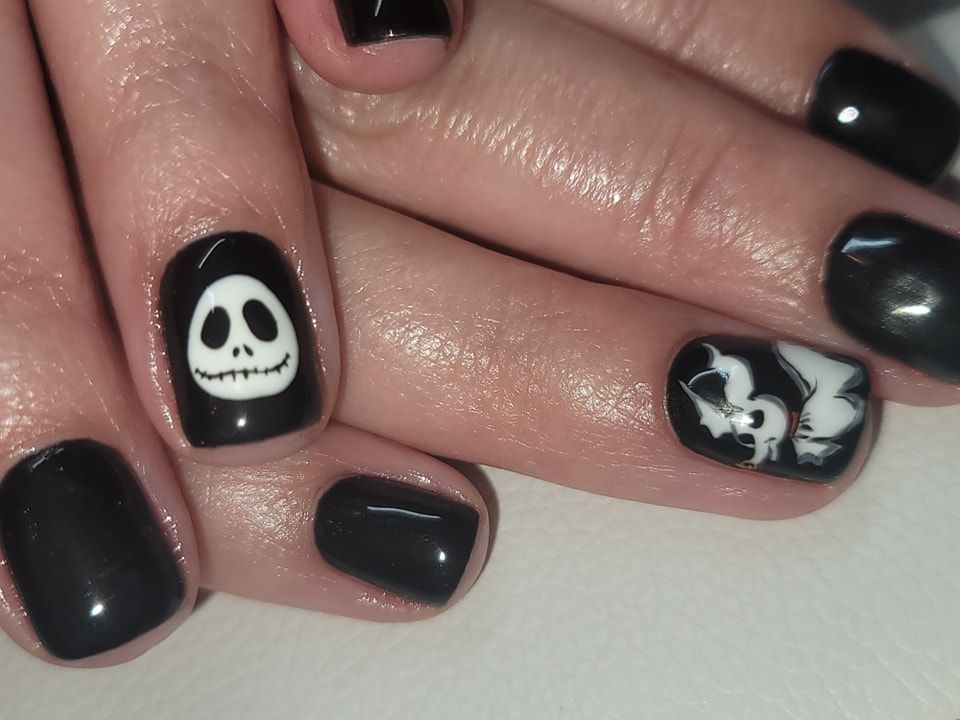 A close up of a person 's nails with a jack skellington design