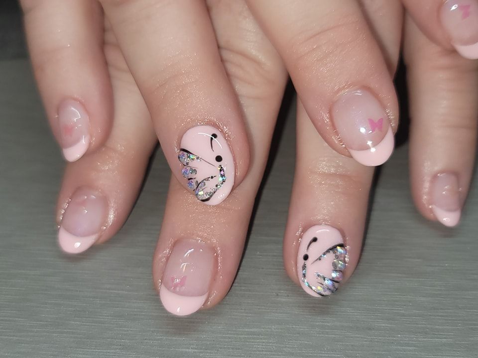 A close up of a woman 's nails with a butterfly design