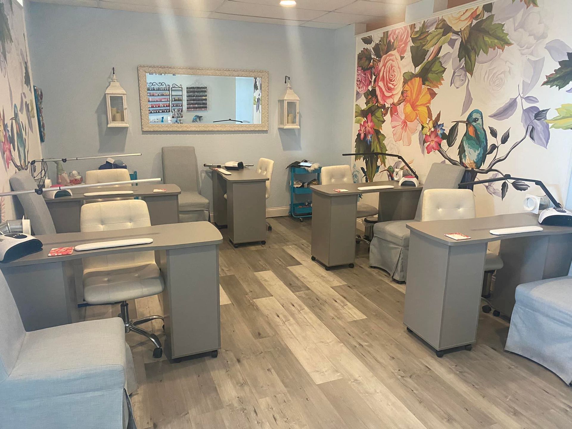 A room filled with tables and chairs in a nail salon.