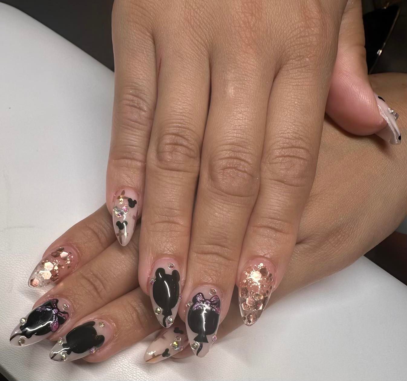 A close up of a woman 's nails with a cow print design