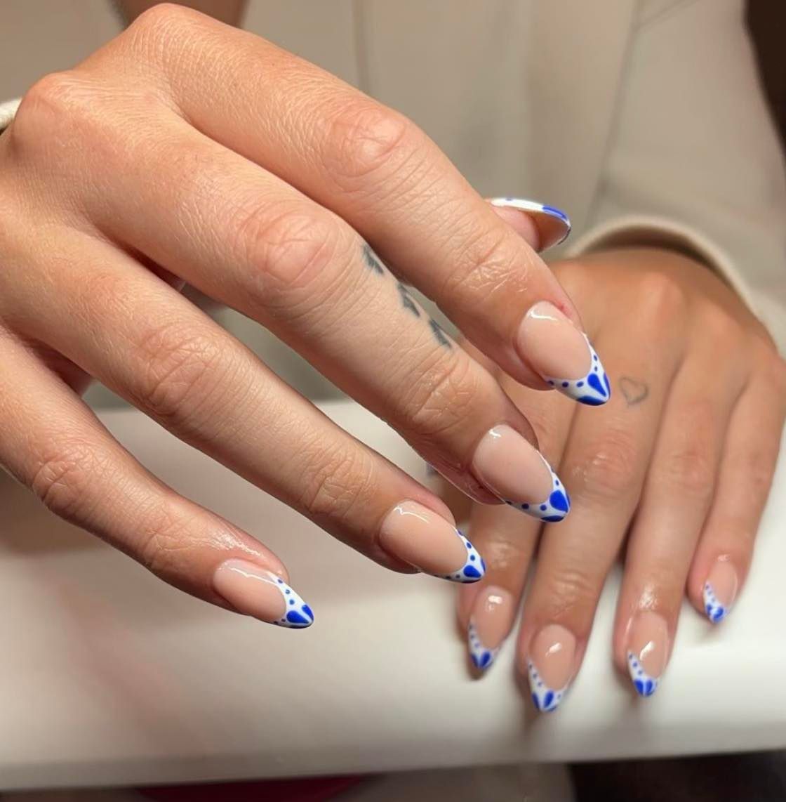 A close up of a woman 's hands with blue and white nails