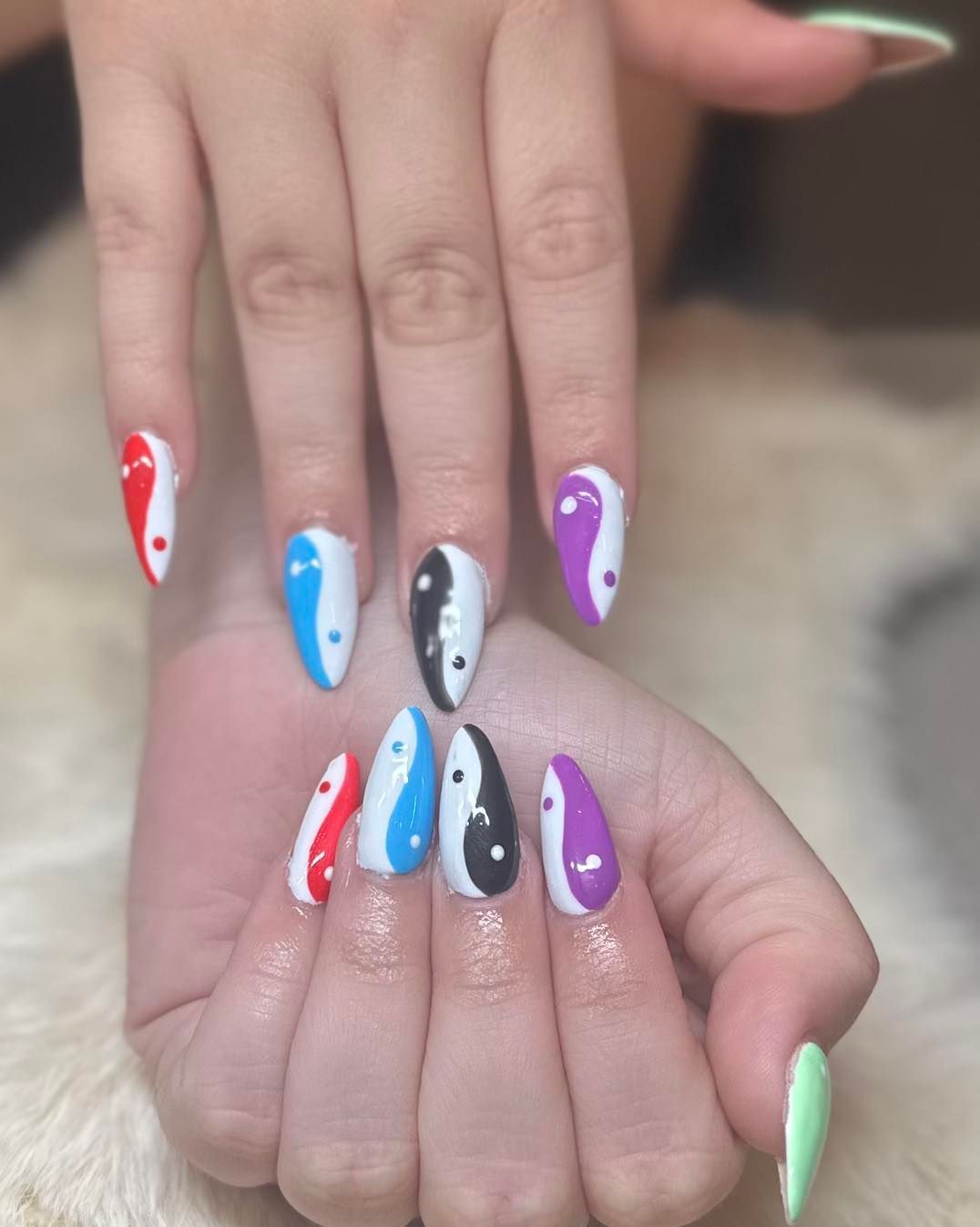 A close up of a person 's nails with a yin yang design.