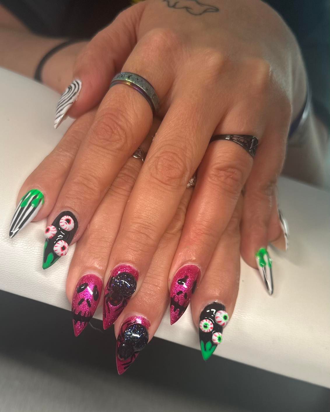 A close up of a woman 's nails with rings on them