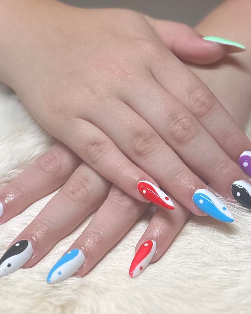 A close up of a woman 's hands with colorful nails