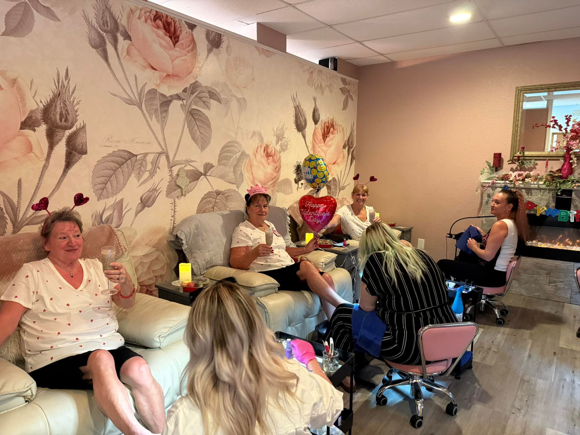 A group of women are sitting in chairs in a nail salon.
