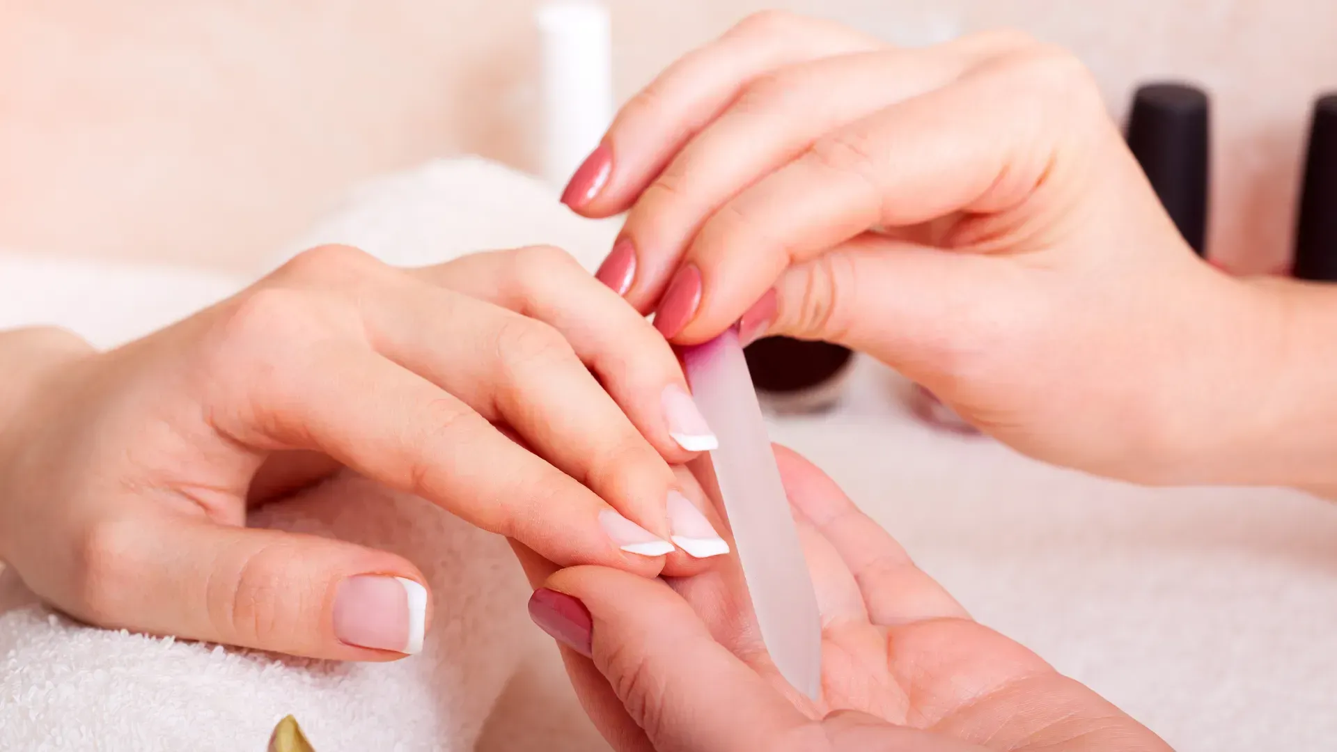 A woman is getting her nails done at a nail salon.