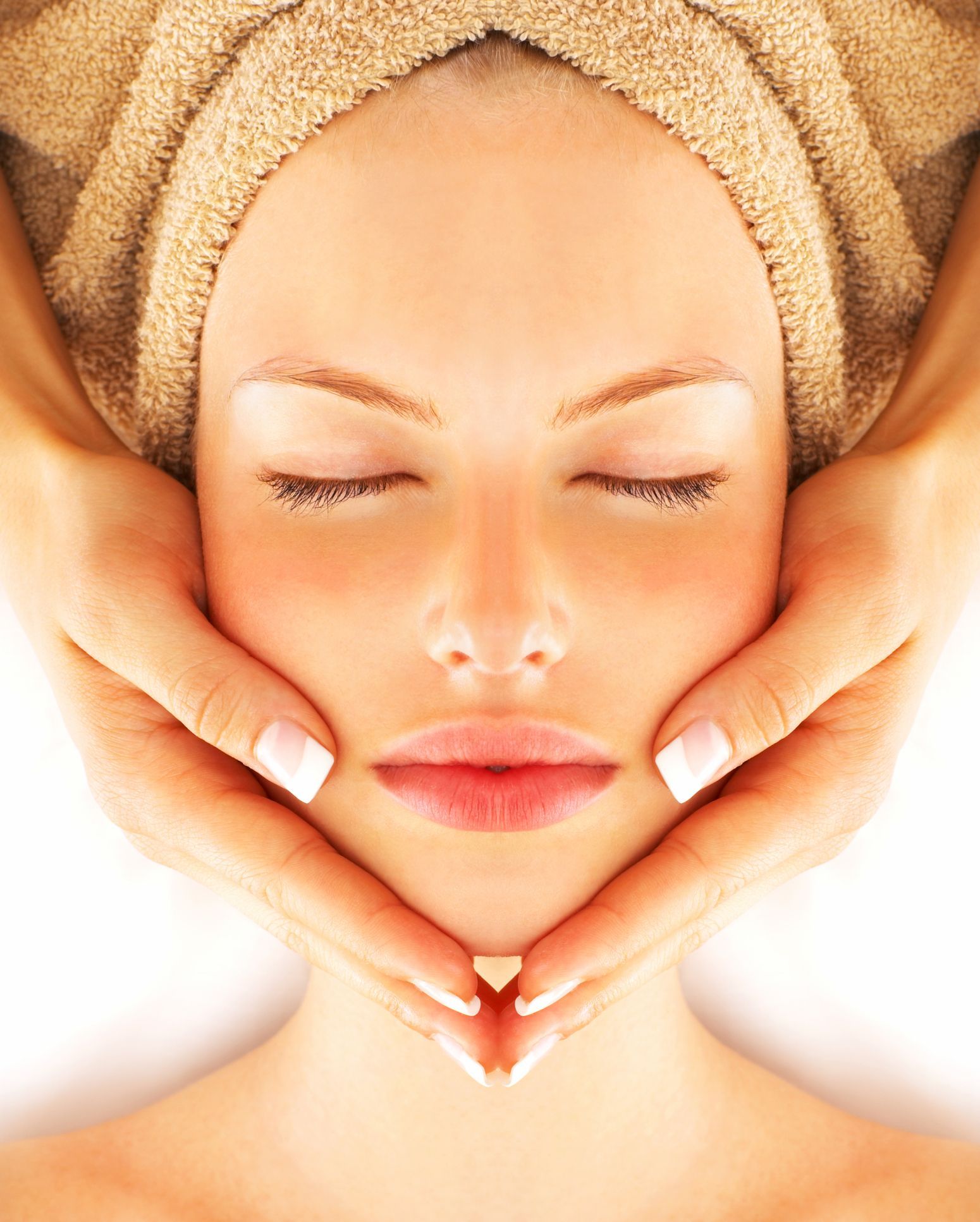 Facial treatment: a person's face being cleaned with a cotton pad by a professional in a spa setting.