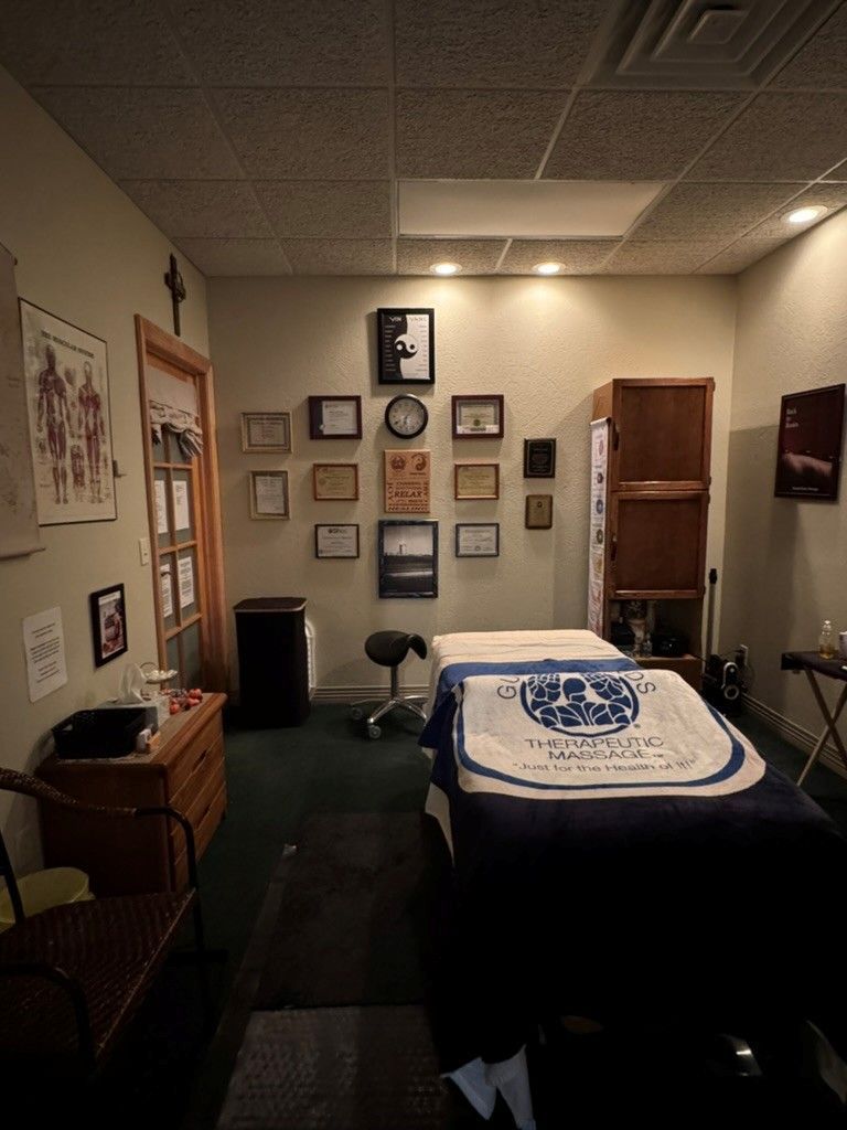 Hands massaging the palm of another hand, on a light-colored surface.