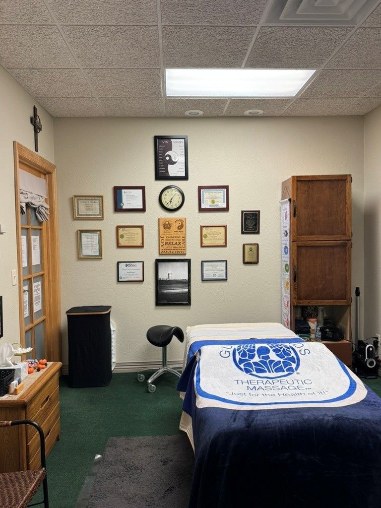 Person receiving a back massage on a massage table, hand applying pressure.
