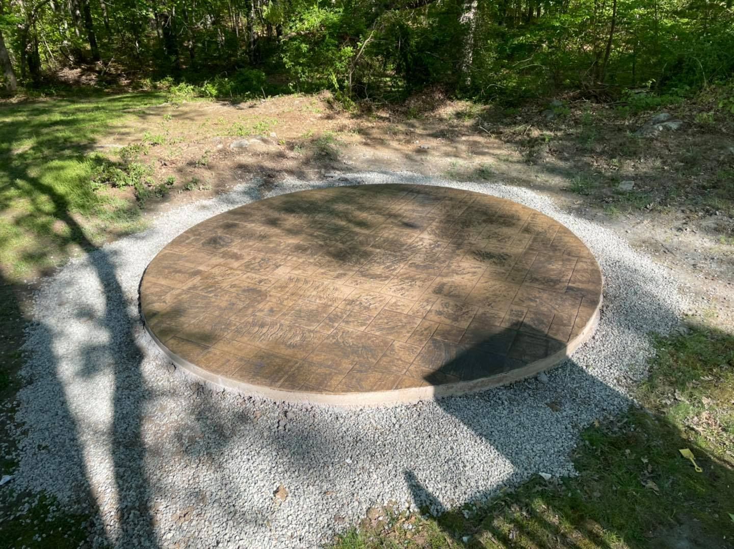 A circle of dirt and gravel in the middle of a yard.