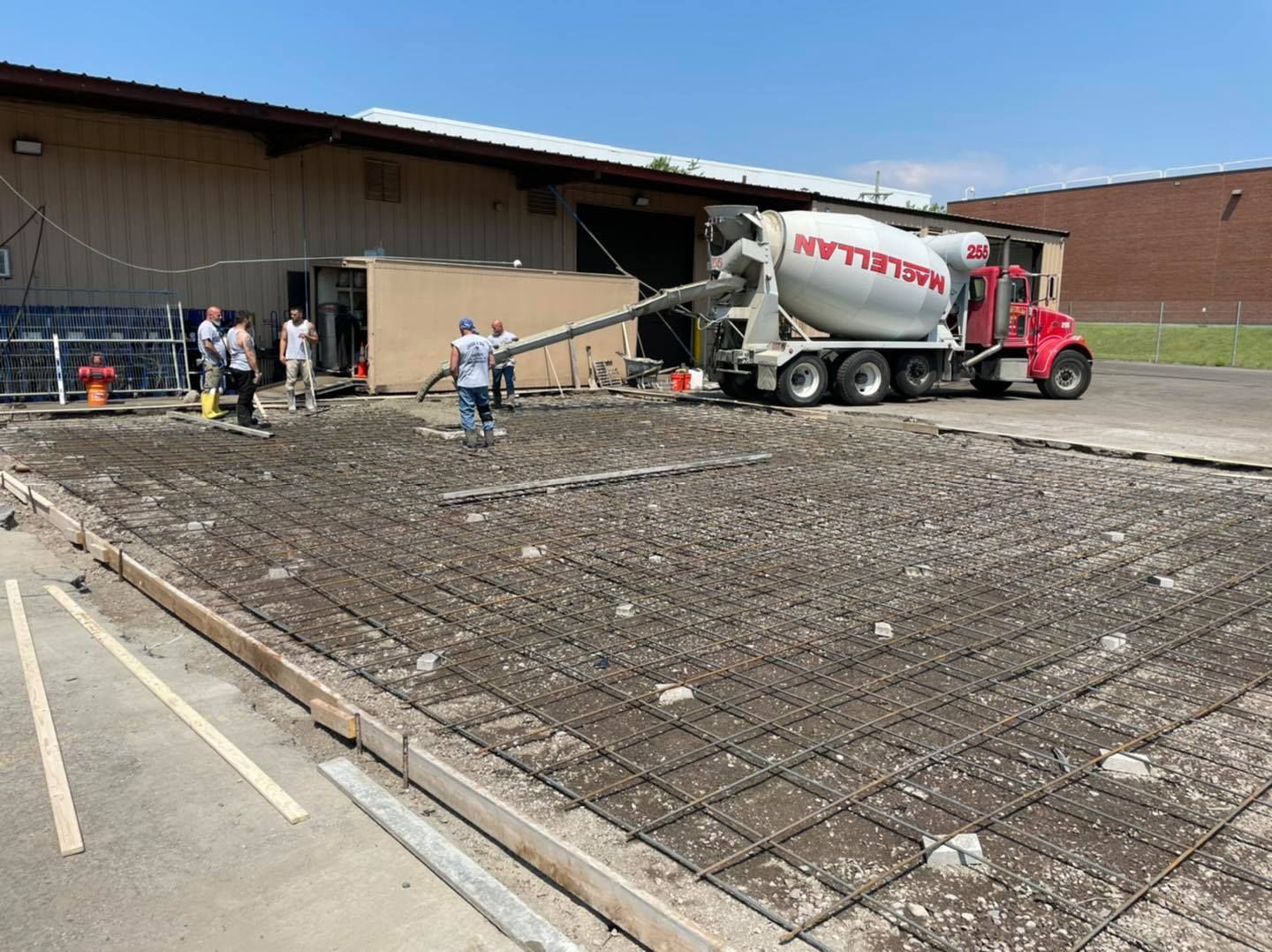 A concrete mixer truck is pouring concrete into a concrete slab.