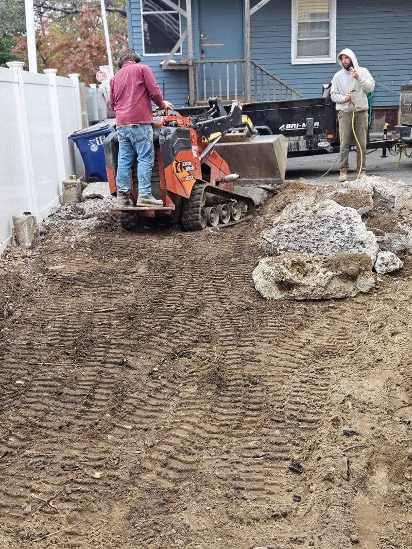 A man is standing next to a bulldozer in a dirt field.