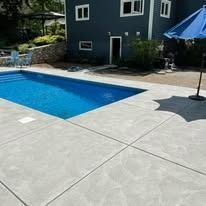 There is a large swimming pool in the backyard of a house.