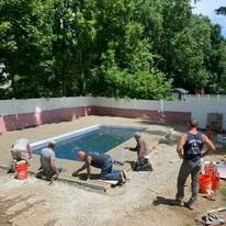 A group of men are working on a swimming pool.