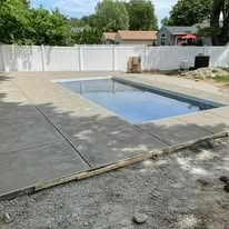 A large swimming pool is being built in a backyard.