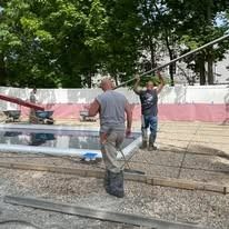 Two men are working on a swimming pool.