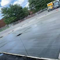 A concrete parking lot with a truck parked in the background.