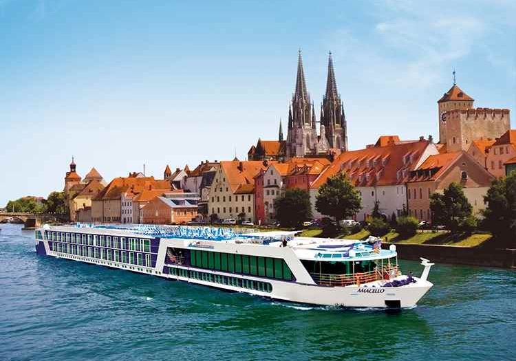 A cruise ship is floating on a river in front of a city.