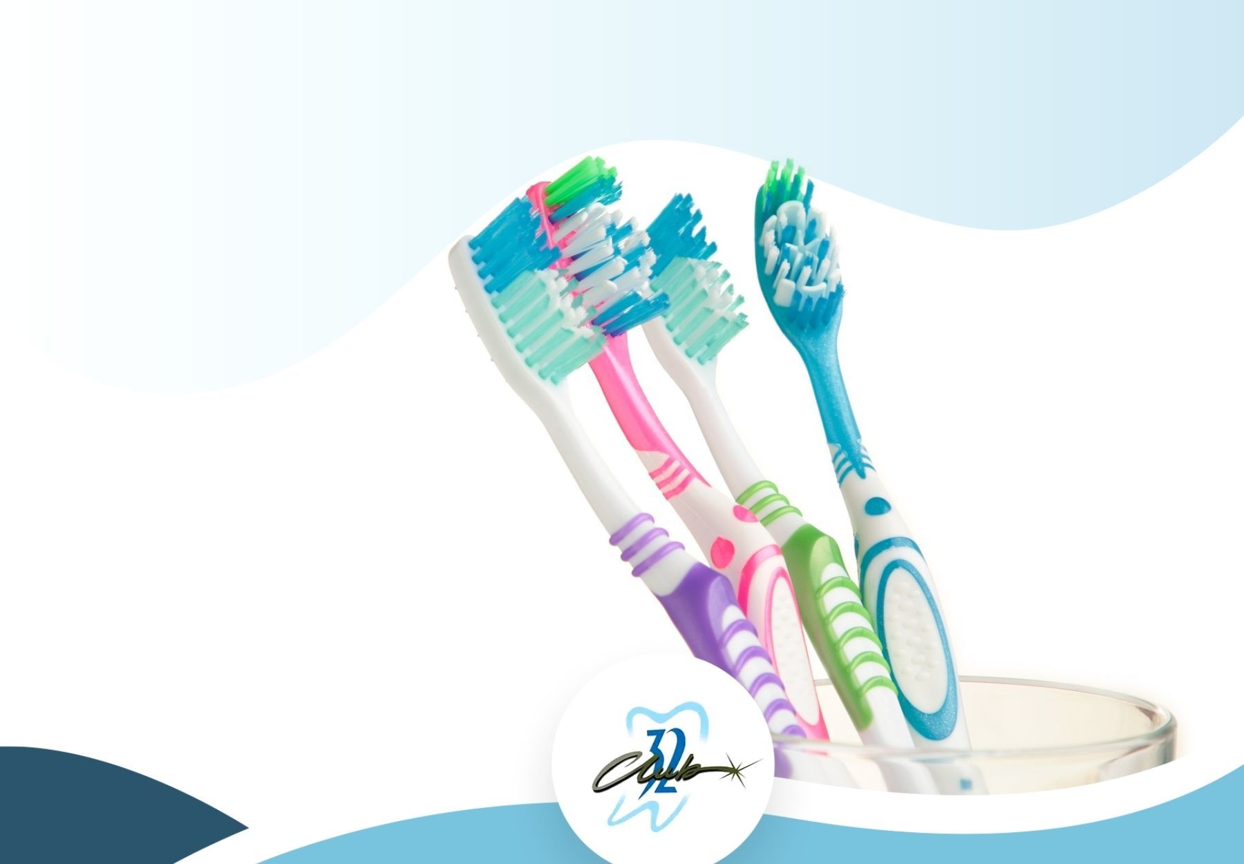 Three toothbrushes are sitting in a glass on a white background.