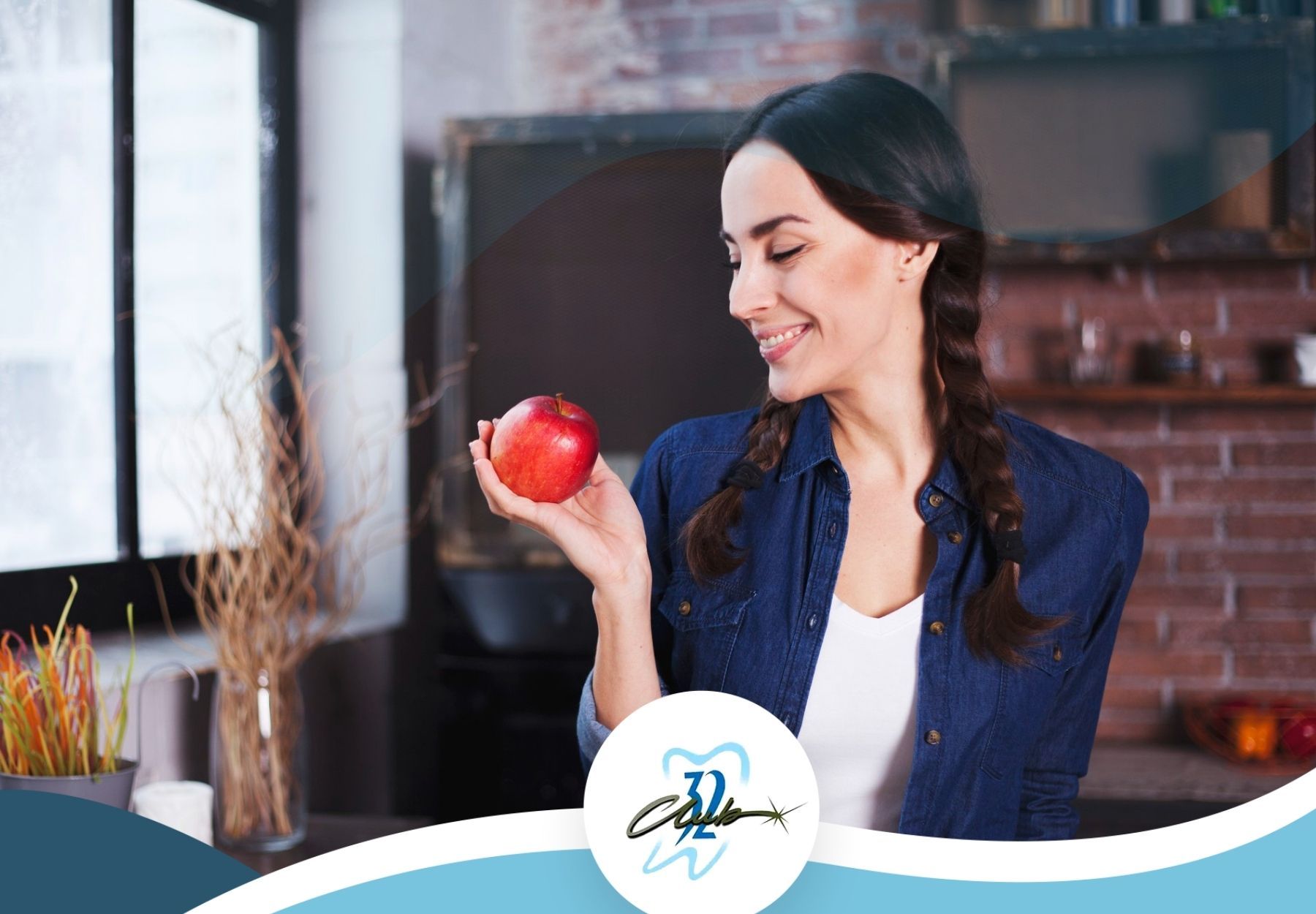 A woman is holding a red apple in her hand and smiling.