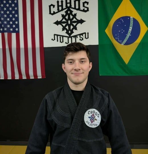 Man in black gi smiling.