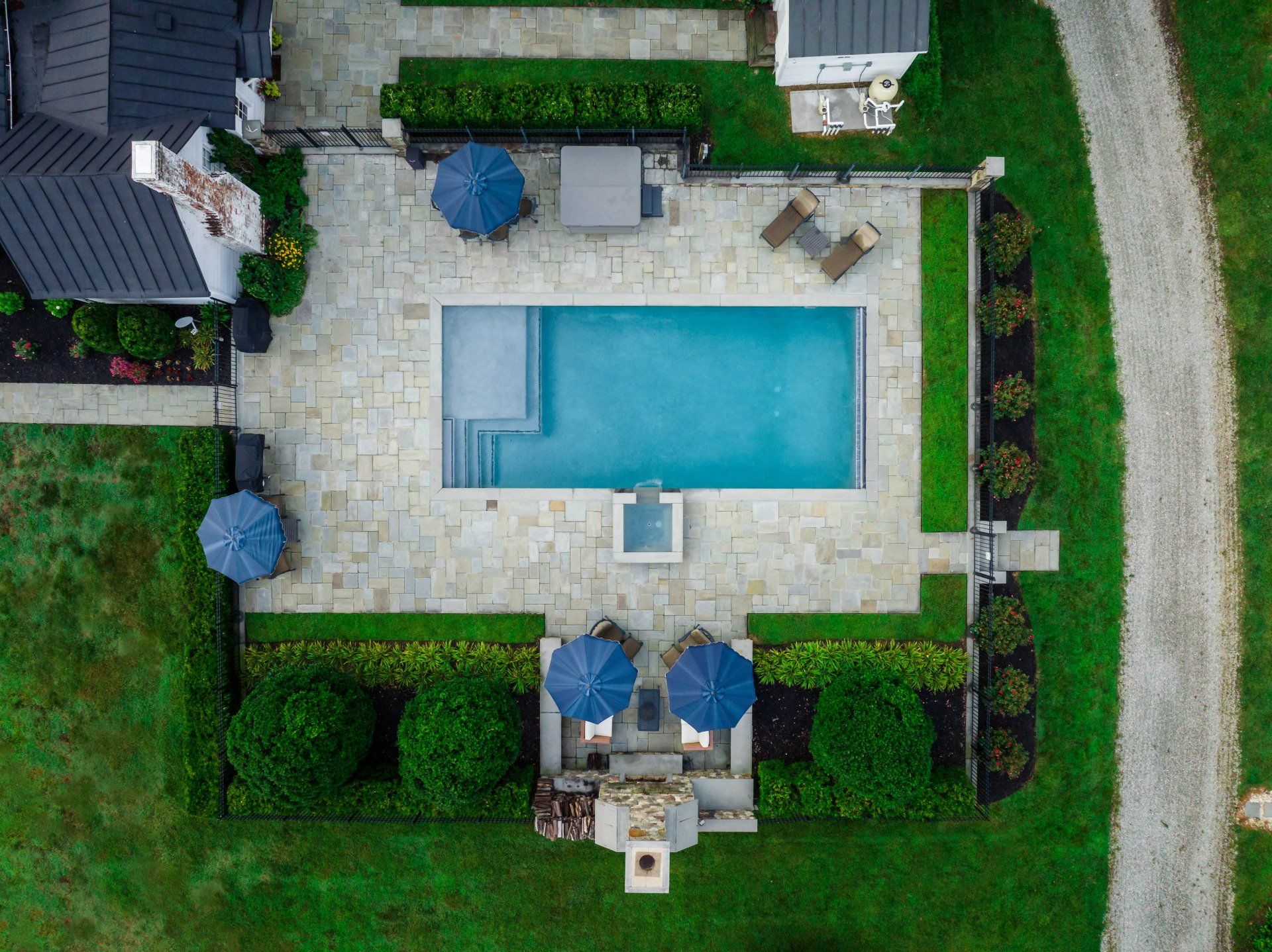 An aerial view of a large swimming pool surrounded by umbrellas and chairs.
